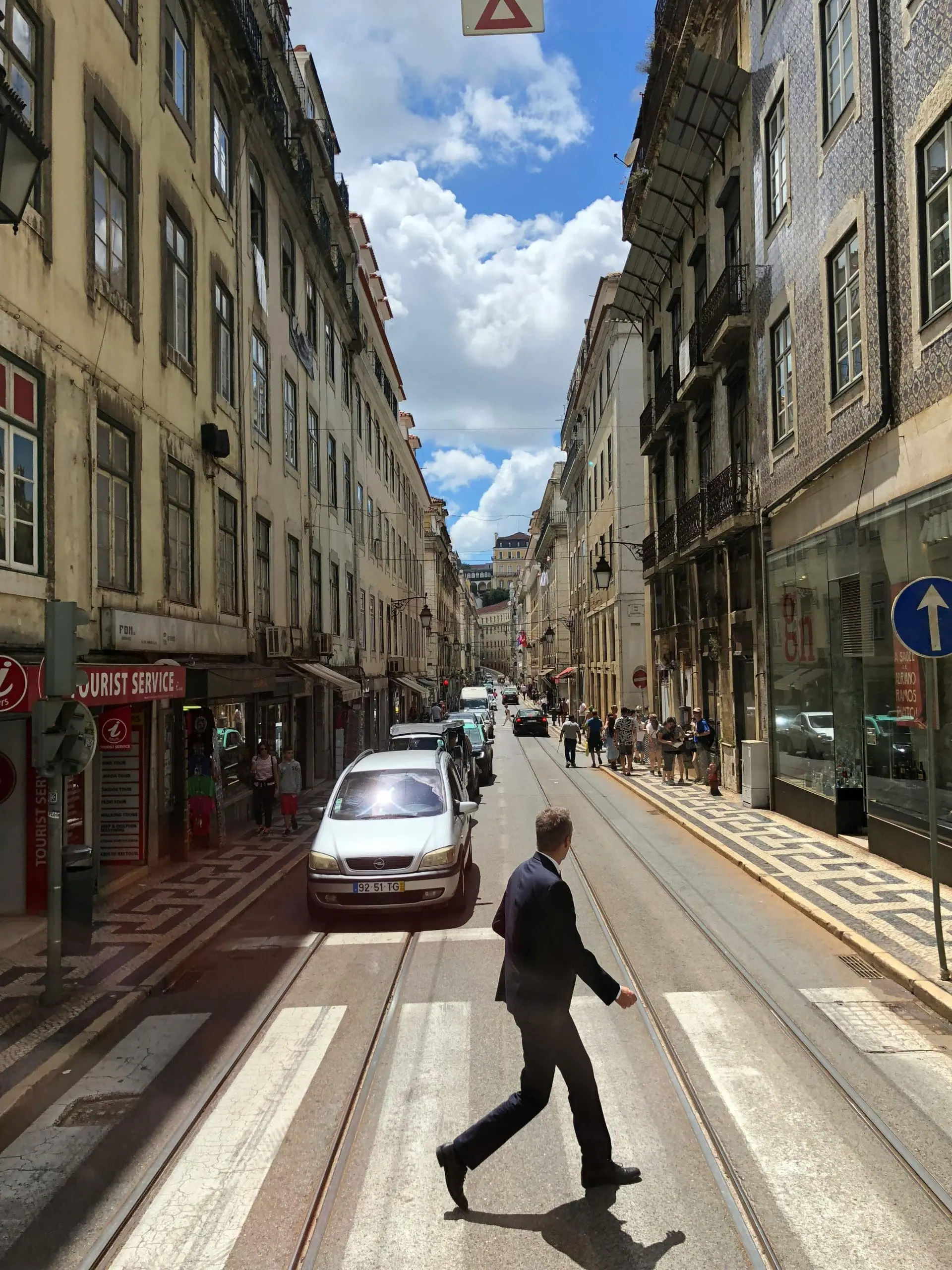 Urban street scene with a man crossing a zebra crossing in Santarém District, Portugal.