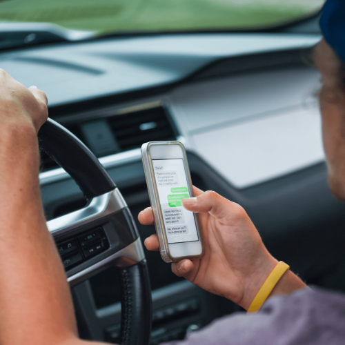 person at the wheel texting while driving.